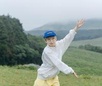 緑豊かな高原で両手を上下に大きく開いている柳瀬 可奈子さんの写真