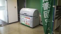 東伊豆町役場に設置された、古着等回収ステーションと書かれた旗の近くに置かれている回収ボックスの写真