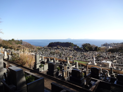 お墓が立ち並ぶ向こうに海が見える東伊豆町営上野墓園の写真