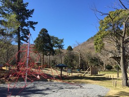 砂場の上に赤いロープで作られたタワーのような遊具の写真