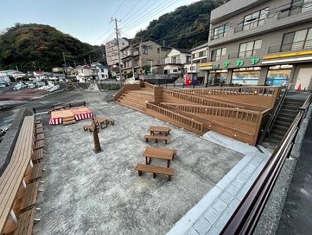 木材でできたスロープの先に憩いの広場があり、そこに机や椅子がおかれているムーンロードテラスの全体像の写真
