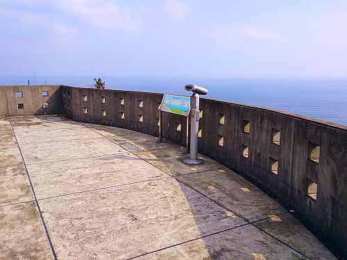 海で囲まれた高台に望遠鏡が1台ある写真